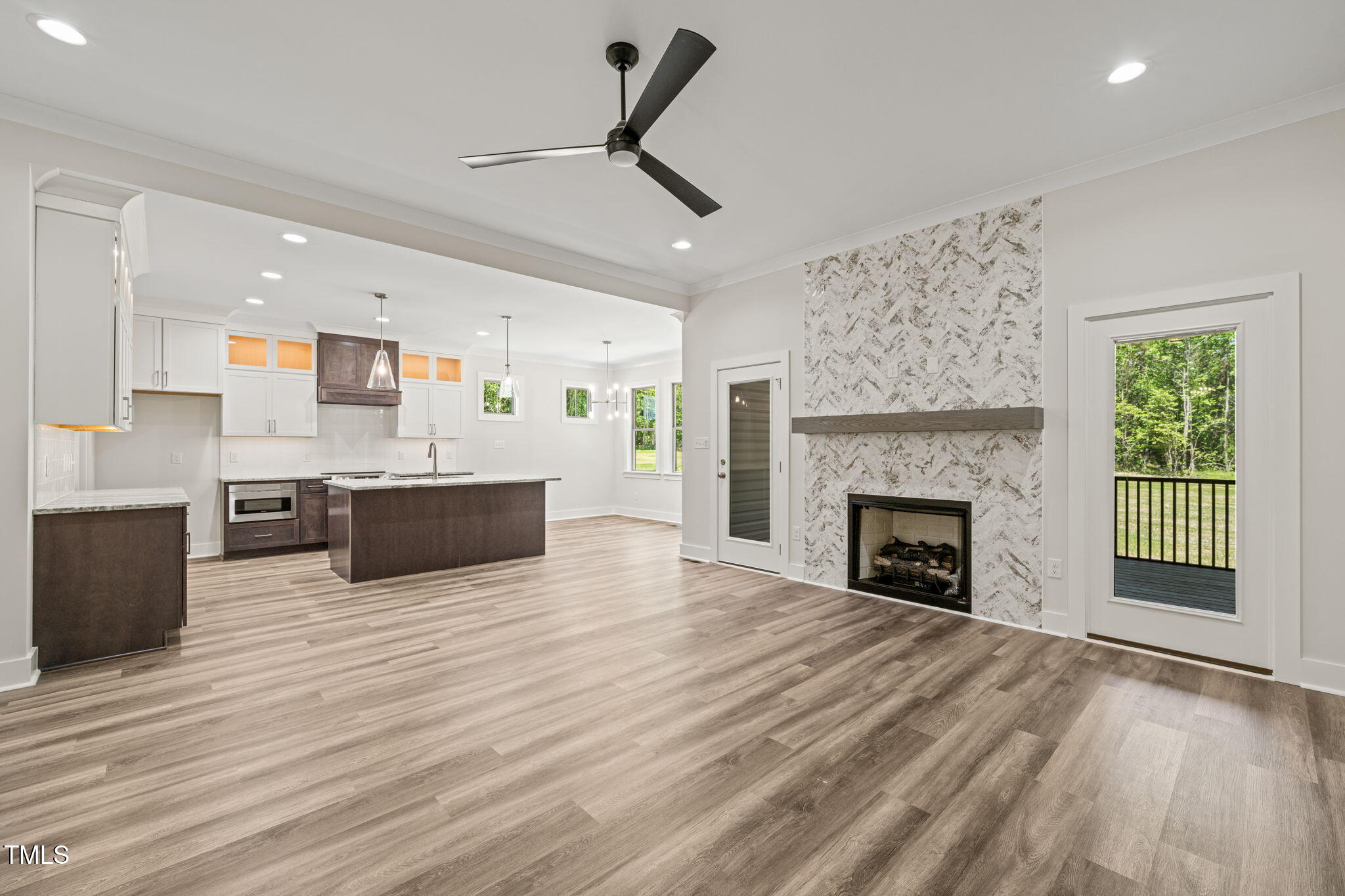 310 Pilot Ridge Road Zebulon, NC 27597 - Photo 7 of 46 a large kitchen with stainless steel appliances granite countertop a stove oven a sink dishwasher and a fireplace with wooden floor