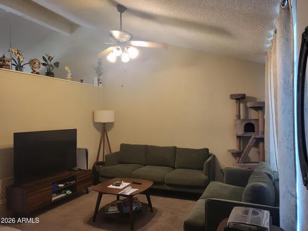 a living room with furniture a flat screen tv and a window