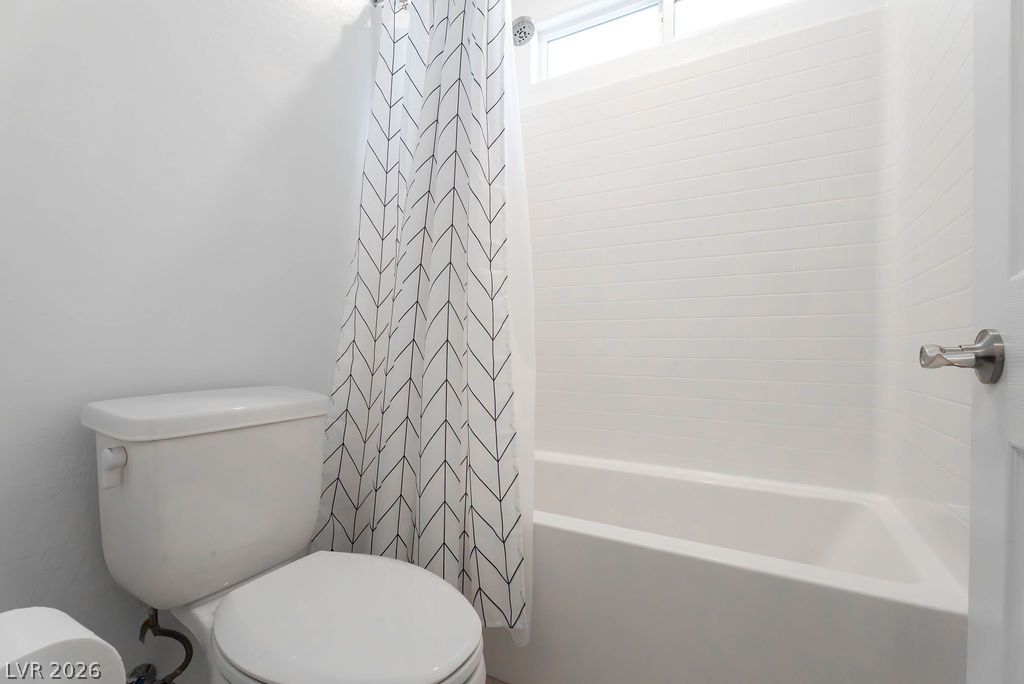 7126 Calvert Cliffs Street North Las Vegas, NV 89084 - Photo 29 of 44 A well-appointed bathroom features a modern toilet and a pristine bathtub with sleek white tiled surround.