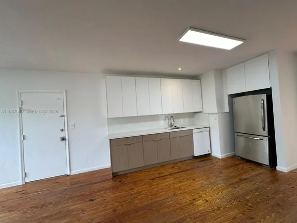 a kitchen with a refrigerator sink and cabinets