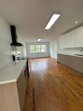 a kitchen with granite countertop a sink a counter space and cabinets