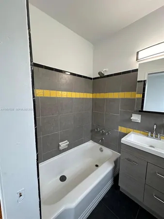 a bathroom with a tub sink and mirror