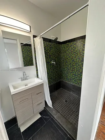 a bathroom with a sink a shower a toilet and mirror