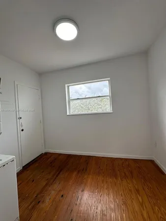 a view of a room with wooden floor and a window
