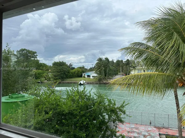 a view of beach and palm trees