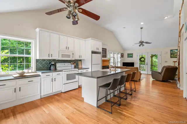 a view of a house with a yard and large trees