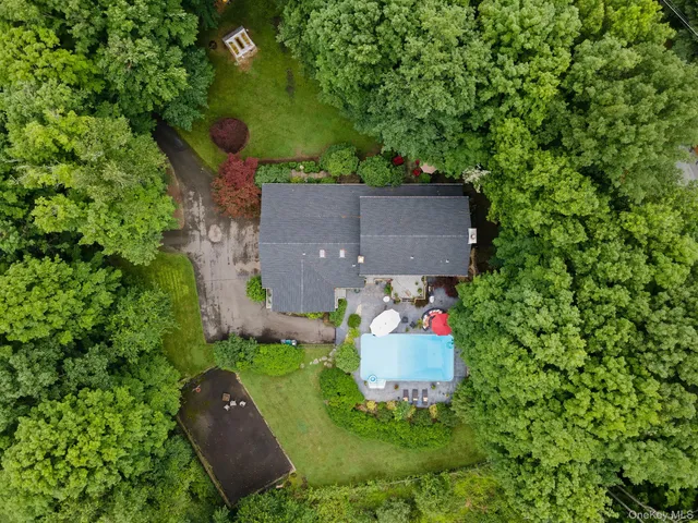 a front view of house with yard and trees in the background