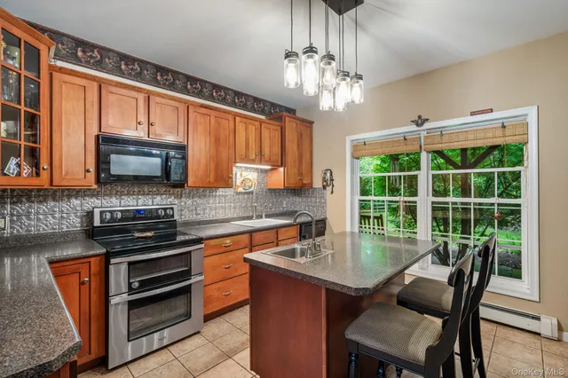 a kitchen with stainless steel appliances granite countertop a stove top oven a sink dishwasher a dining table and chairs with wooden floor