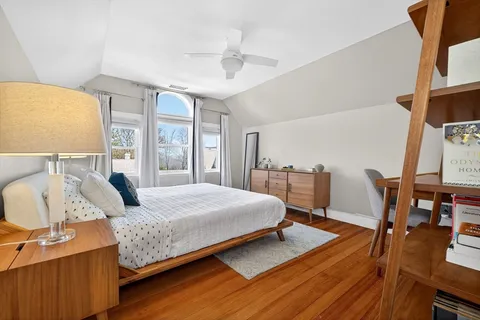 a bedroom with a bed a bookshelf and a large window