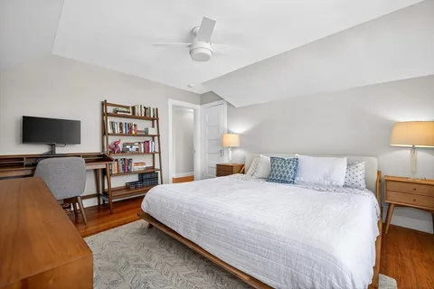 a bedroom with a bed bookshelf and a chair