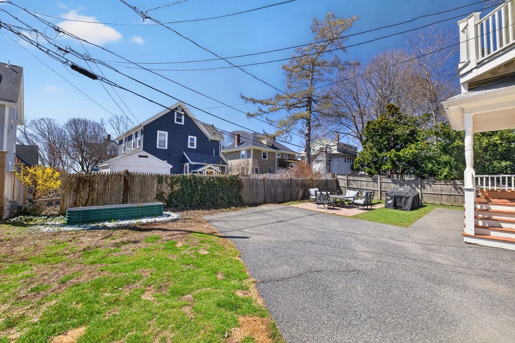 16 Primrose Street, Unit 3 Boston, MA 02131 - Photo 21 of 26 a view of a backyard with a table and chairs under an umbrella