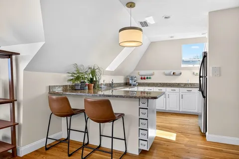 a kitchen with stainless steel appliances granite countertop a kitchen island a stove and a sink