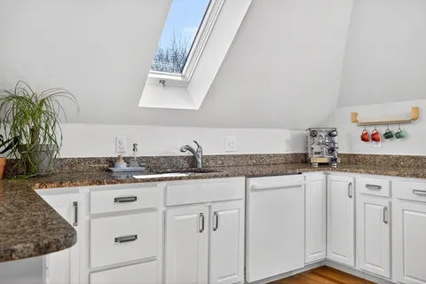a kitchen with granite countertop a sink and cabinets