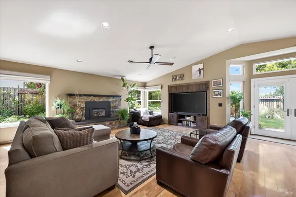 a living room with fireplace furniture and a large window