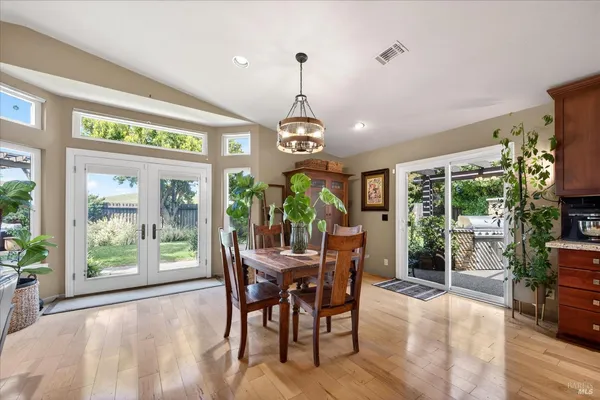 a dining room with furniture a chandelier and wooden floor