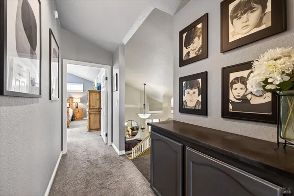 a view of a hallway with wooden floor and furniture