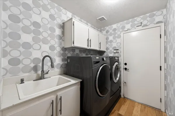 a utility room with sink dryer and washer