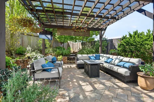a view of a patio with couches table and chairs and potted plants