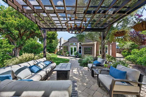 a view of a patio with couches table and chairs and potted plants