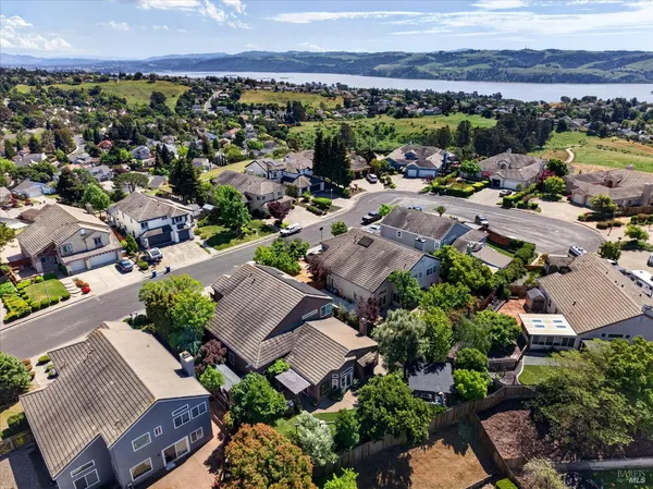 an aerial view of a city with lots of residential buildings and mountain view in back