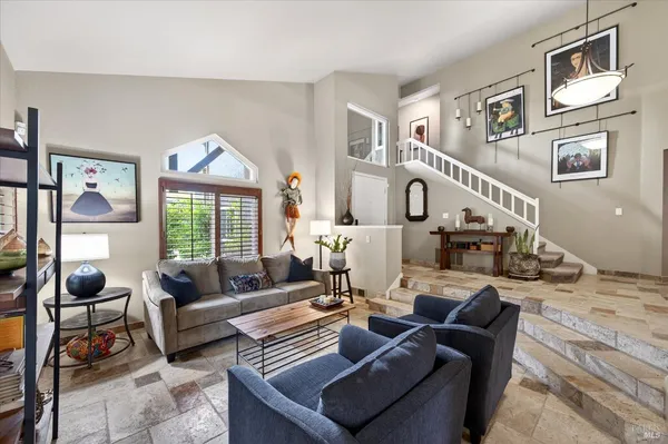 a living room with furniture fireplace and a large window