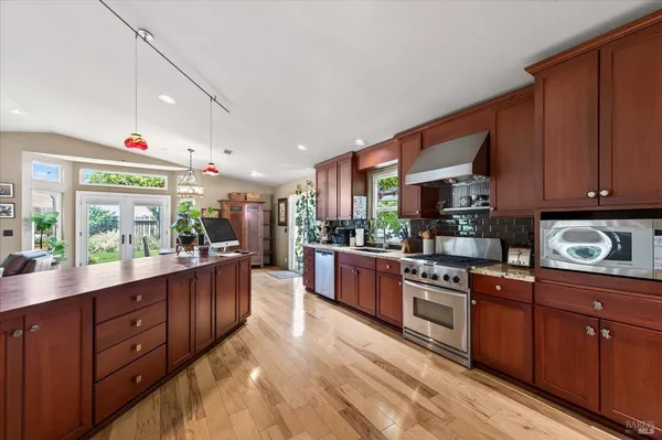 a kitchen with stainless steel appliances granite countertop a stove a sink and a refrigerator