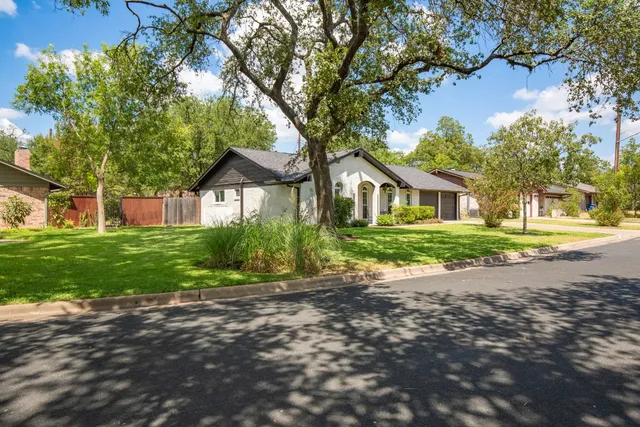 a front view of a house with a yard and trees