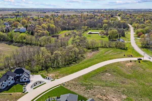 an aerial view of a house with a yard and lake view
