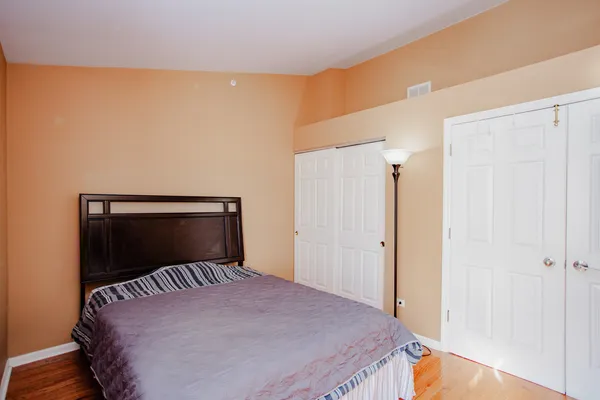 a bedroom with a bed and wooden floor