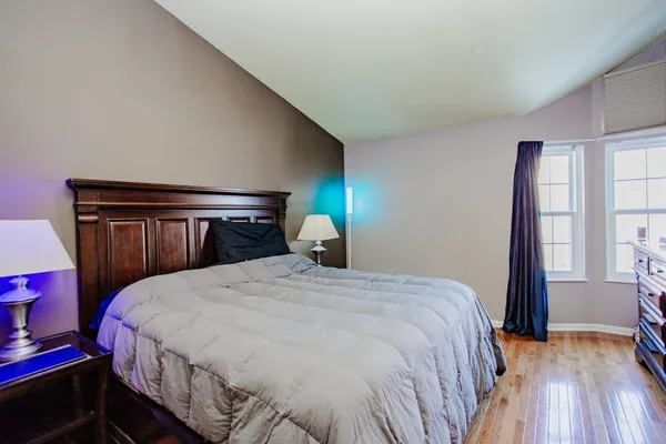 a bedroom with a bed and wooden floor