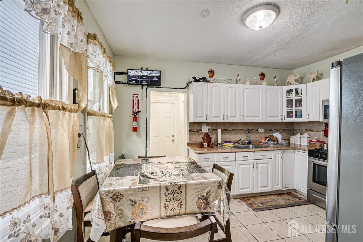 438 Lawrie Street Perth Amboy, NJ 08861 - Photo 19 of 49 a kitchen with a sink refrigerator and cabinets