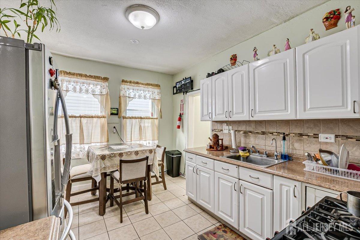 438 Lawrie Street Perth Amboy, NJ 08861 - Photo 21 of 49 a kitchen with white cabinets and sink