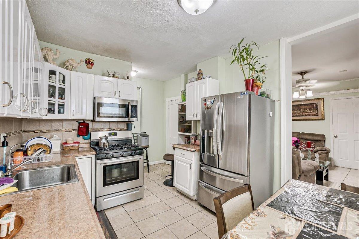 438 Lawrie Street Perth Amboy, NJ 08861 - Photo 22 of 49 a kitchen with stainless steel appliances a stove a refrigerator and cabinets