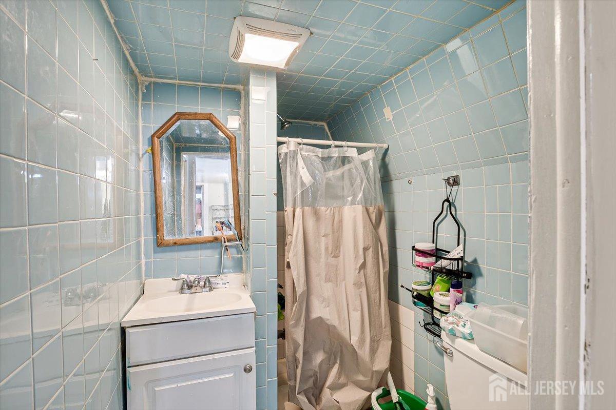 438 Lawrie Street Perth Amboy, NJ 08861 - Photo 34 of 49 a bathroom with a sink mirror and vanity