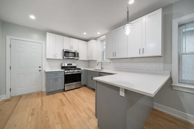 a kitchen with a sink a microwave a stove and refrigerator