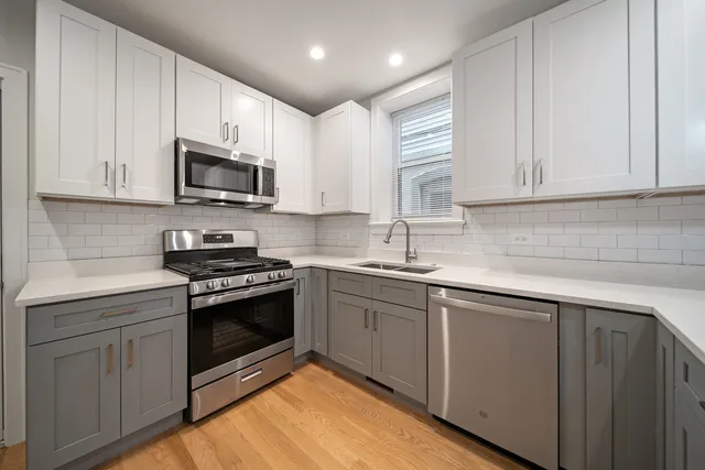 a kitchen with cabinets stainless steel appliances a sink and a window