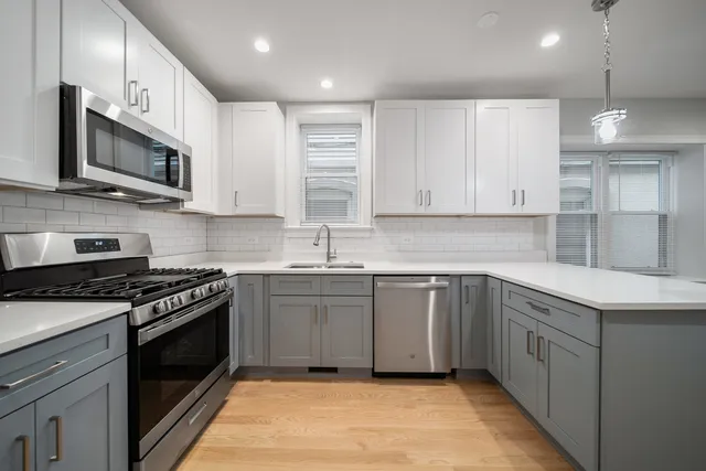 a kitchen with stainless steel appliances granite countertop a sink and a stove