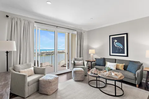 a living room with furniture and a large window with balcony view