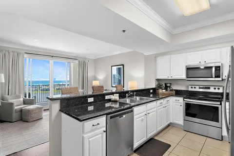 a kitchen with granite countertop a sink and a stove top oven