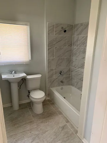 a white toilet sitting next to a bath tub