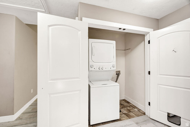 778 South 650 West Logan, UT 84321 - Photo 20 of 26 Laundry closet featuring a white stacked washer and dryer, tile flooring, and a hanging rod