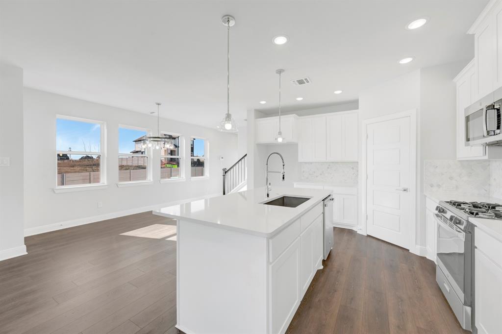3501 Pineda Way McKinney, TX 75071 - Photo 23 of 40 a kitchen with stainless steel appliances granite countertop a sink a stove and a wooden floors