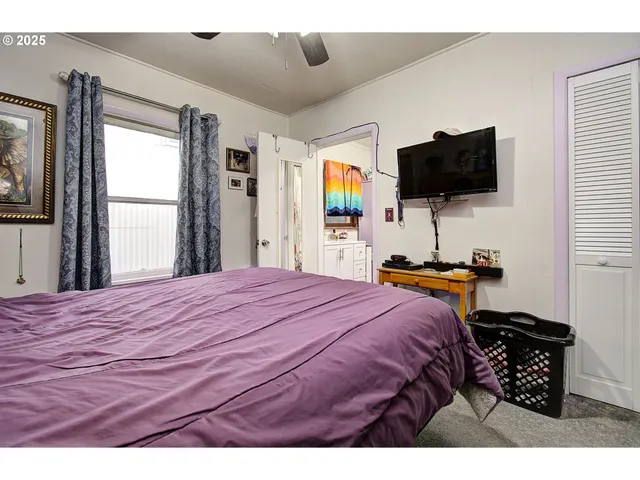 a bedroom with a bed and a flat screen tv