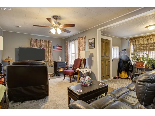 a living room with furniture a flat screen tv and a window