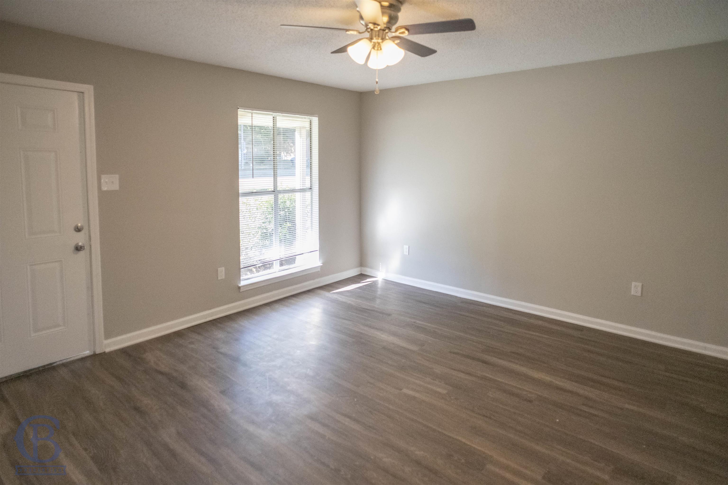 3346 Ridgemont Road Memphis, TN 38128 - Photo 3 of 12 an empty room with wooden floor chandelier fan and windows