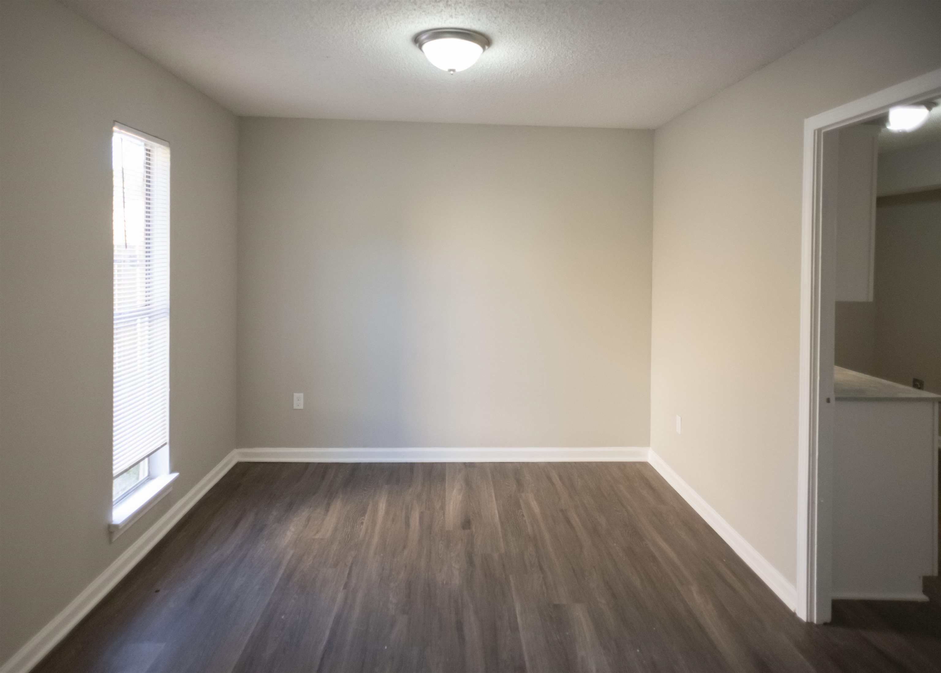 3346 Ridgemont Road Memphis, TN 38128 - Photo 6 of 12 an empty room with wooden floor and windows