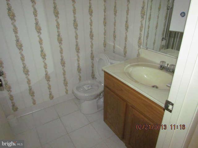15311 Beaverbrook Court, Unit 902G Silver Spring, MD 20906 - Photo 8 of 10 a bathroom with a granite countertop sink toilet and shower
