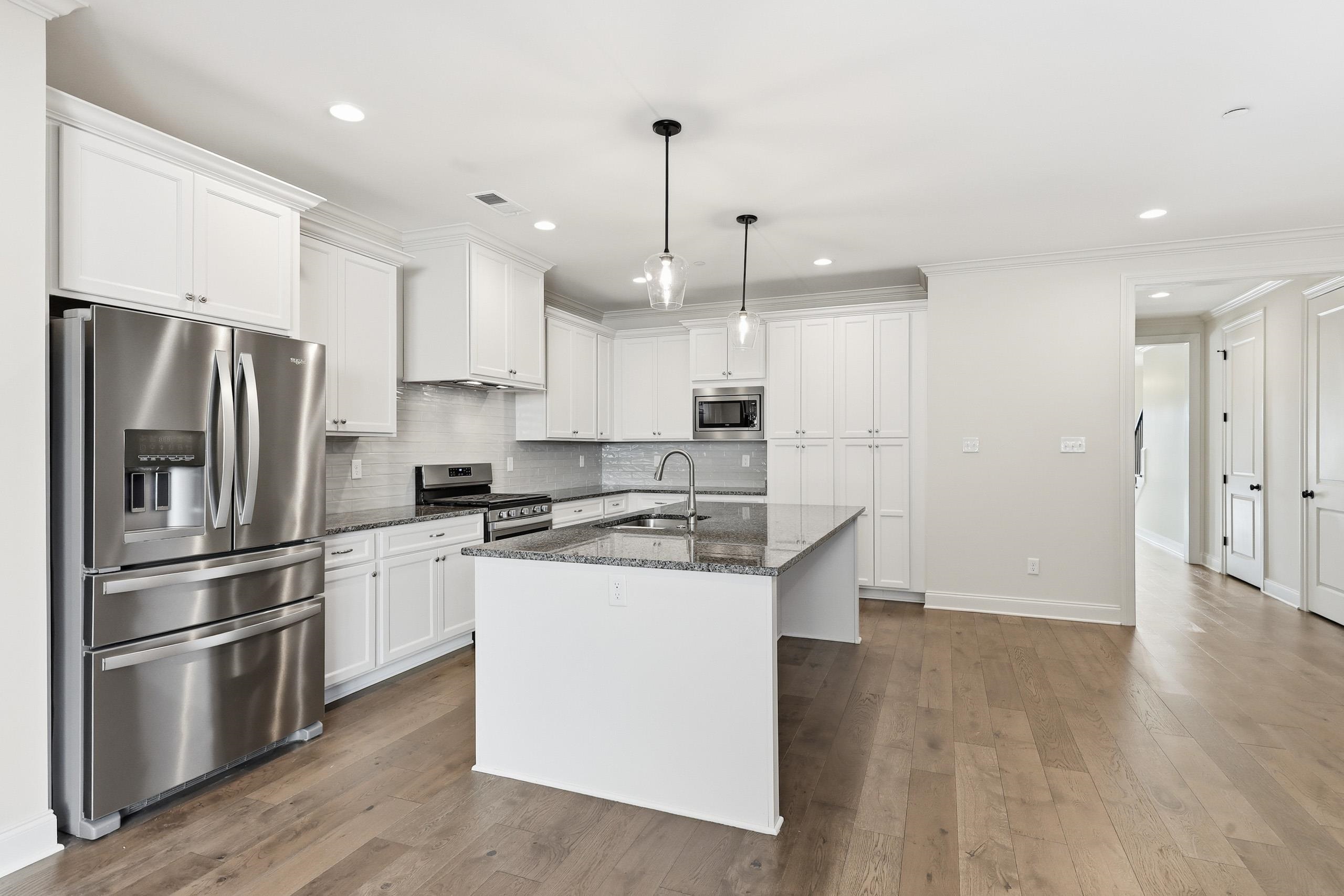 897 Ufton Alley Collierville, TN 38017 - Photo 8 of 32 a kitchen with stainless steel appliances granite countertop a refrigerator a stove a sink and white cabinets