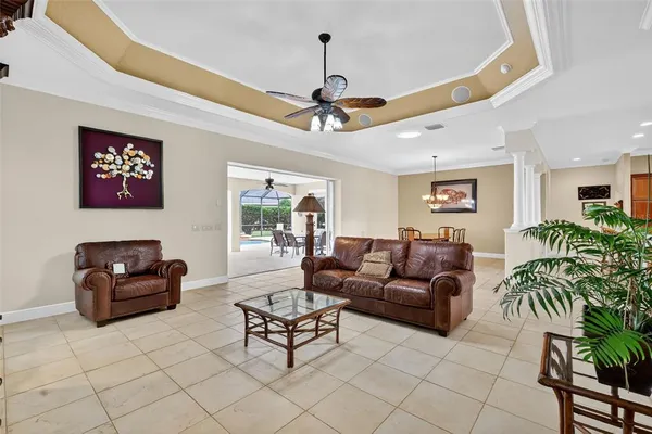 a view of an empty room and chandelier fan