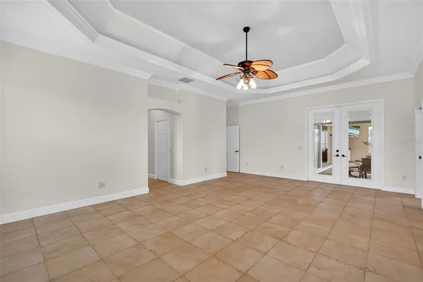 an empty room with windows and fan